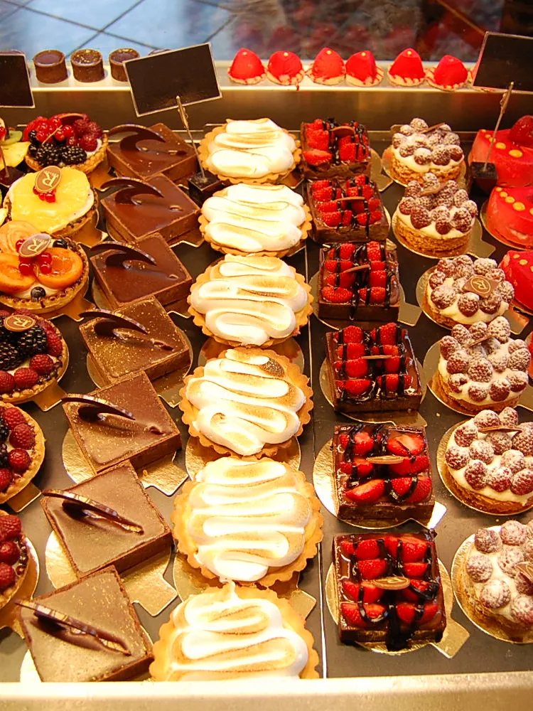 Tresenauslage mit Törtchen, Tartelettes und Kuchen