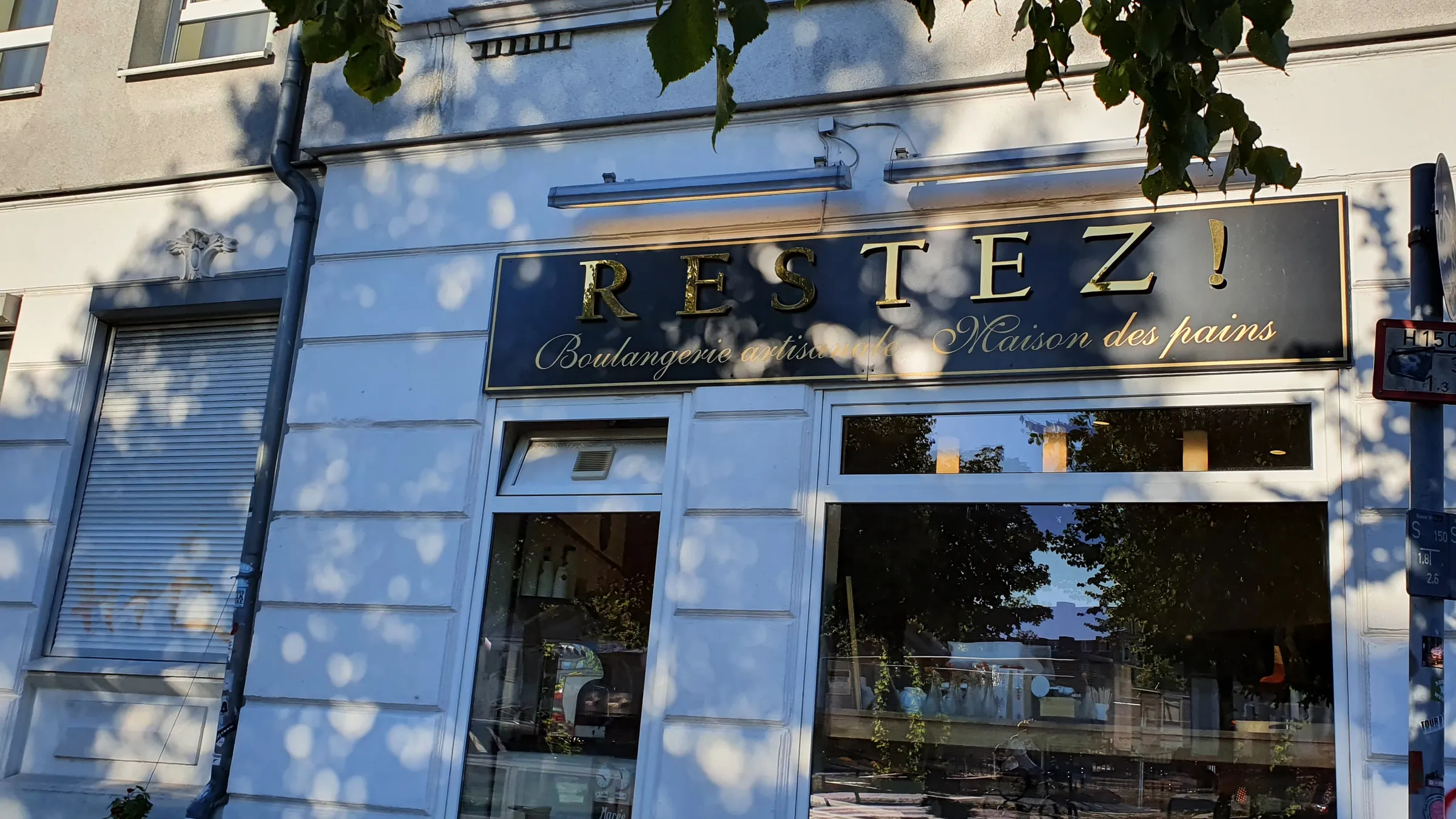 Ladenschild „Restez! Boulangerie artisanale · Maison des pains“ am Stammhaus in der Sternstraße